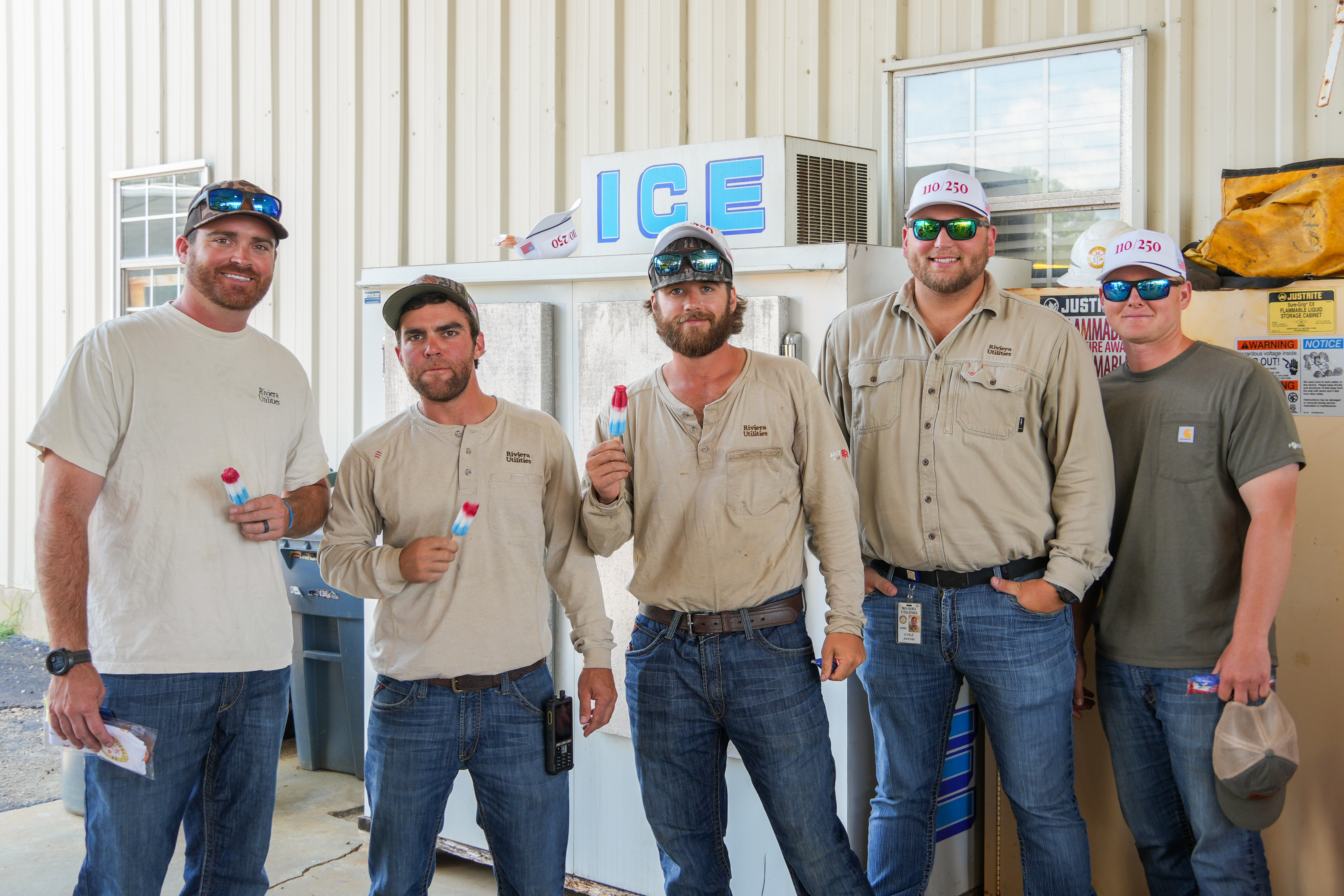 Riviera Utilities employees wearing commemorative 110/250 hats